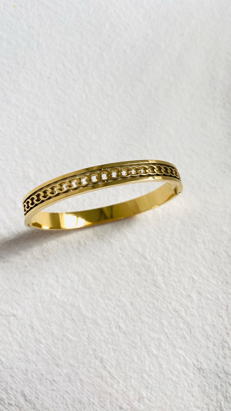 Sleek gold bangle with an intricate chain-link design