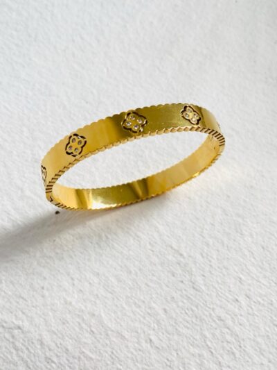 Elegant gold bangle with delicate floral motifs for a timeless charm